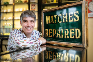 (c) Christopher Ison Photography – ISON_200715_Allnutt_540097 Geoff Allnutt of JE Allnutt & Son next to a 'watches repaired' sign at his shop in West Street, Midhurst, Sussex.