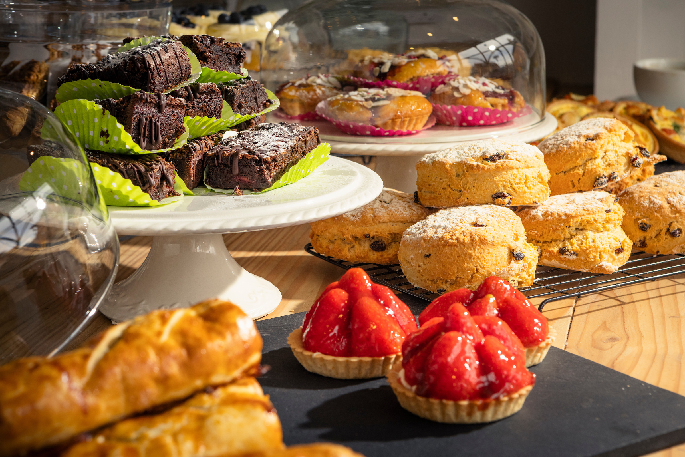 A closeup of an assortment of scones, pastries, and brownies amongst other sweet confectionaries at Tilly's Tea Room in Midhurst, West Sussex.