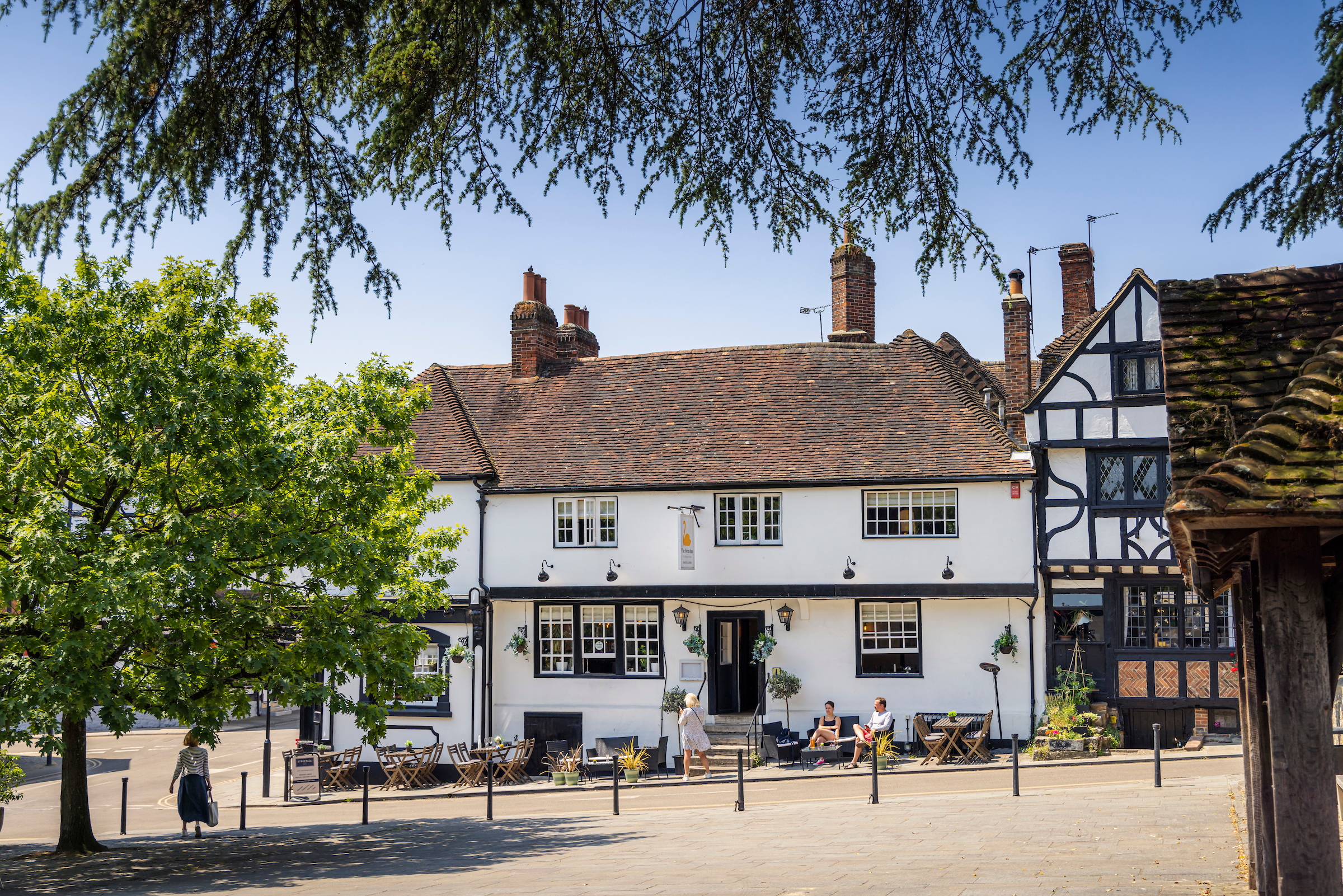 The exterior of The Swan pub in Midhurst West Sussex as seen from Midhurst town square on a sunny day.