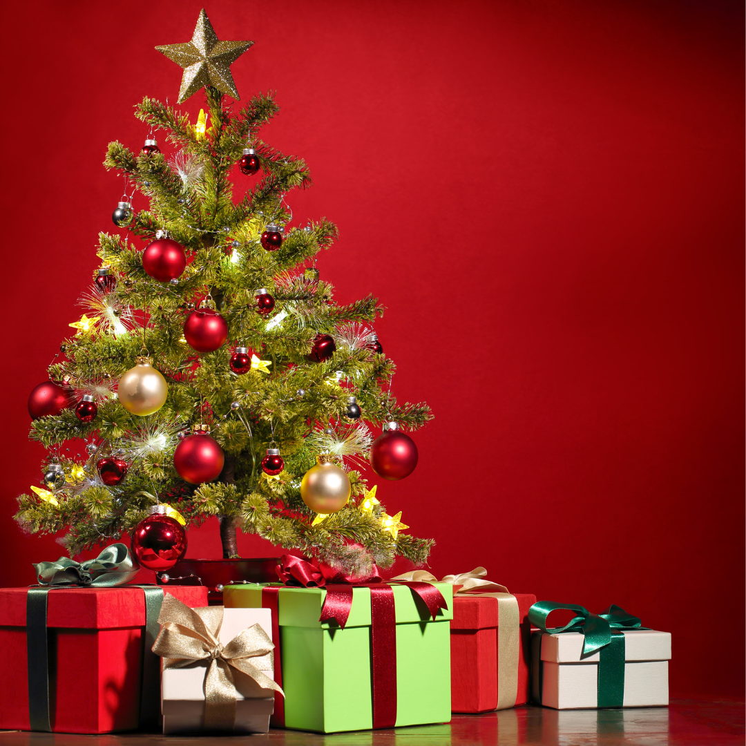 A decorated Christmas tree on a red background with five boxed and wrapped presents underneath.