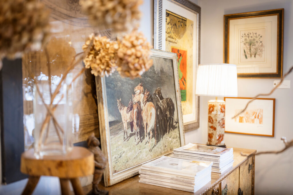 (c) Christopher Ison Photography – ISON_230624_OliveInt_3718 A closeup of four country house style paintings and a lamp inside Olive Interiors in Midhurst, West Sussex.